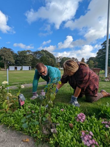 Gavin and Maria digging weeds at the Gardening Club