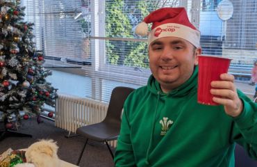 Andrew holding a red cup and celebrating Christmas at Ramsgate Hub