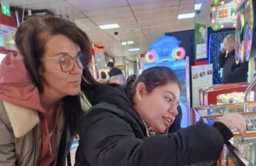 Two ladies at an arcade, one is in a wheelchair