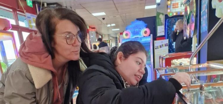 Two ladies at an arcade, one is in a wheelchair