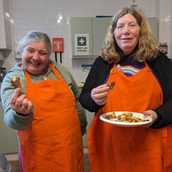 Rosie and Nicola holding a plate of homemade chips