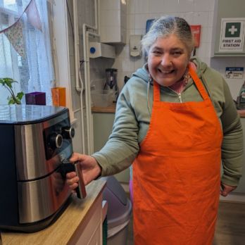 Rosie smiling at the camera using the air fryer 