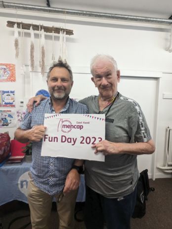 Jason and David holding a Fun Day sign