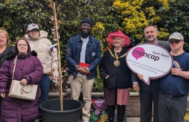 Six people in the Ramsgate Hub garden with the Mayor of Ramsgate planting a tree to celebrate our 75th anniversary