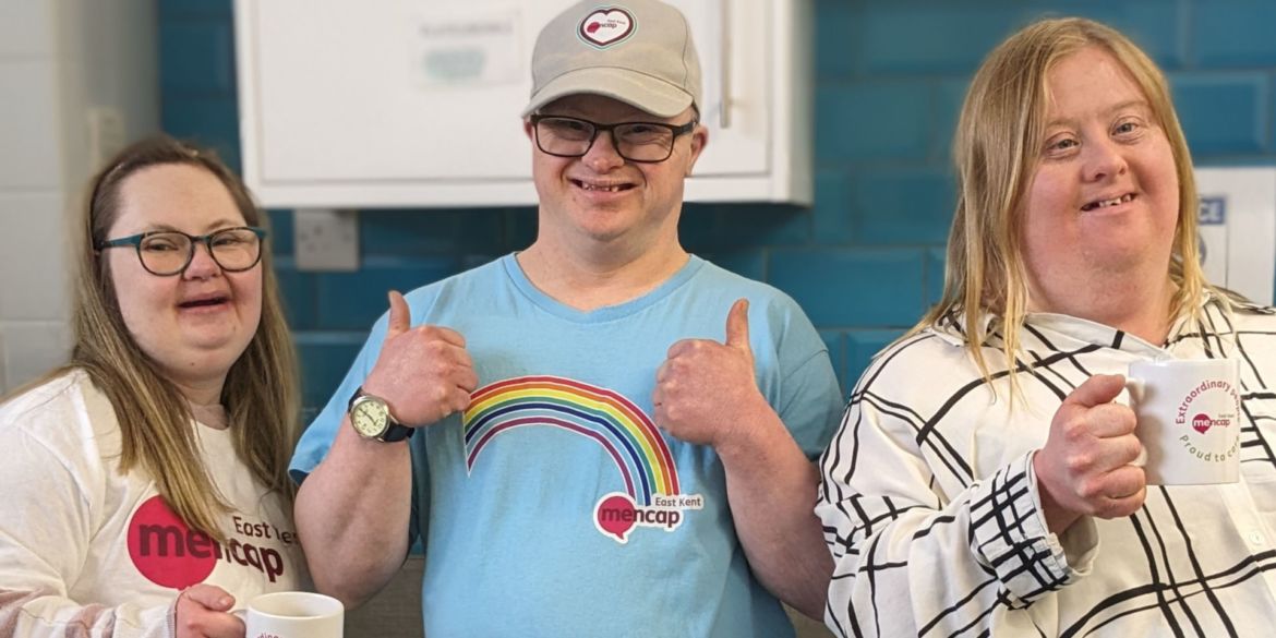 Lucy, Neil and Natalie smiling. Neil has his thumbs up and Lucy and Natalie are holding mugs