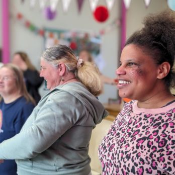 Three women smiling and singing