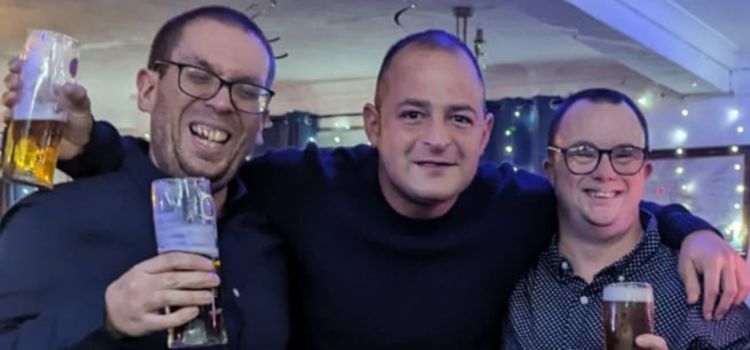 Three men smiling and holding drinks