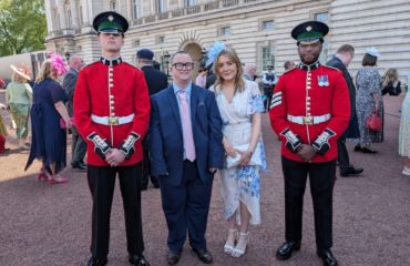 Laurie and Katie with guards outside Buckingham Palace