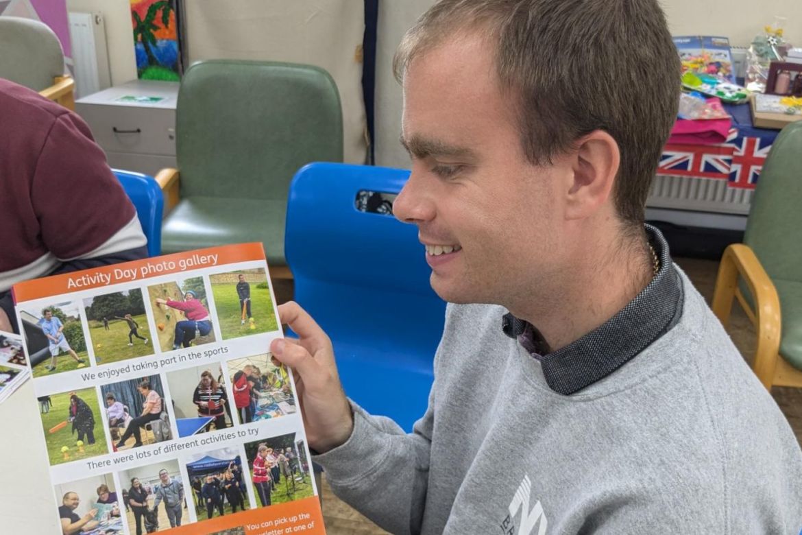 Stephen is smiling looking at the summer newsletter photo gallery