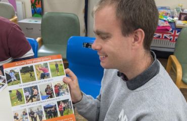 Stephen is smiling looking at the summer newsletter photo gallery