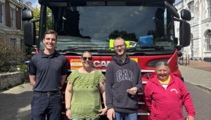 Fire Brigade from Ramsgate, standing in front of a fire engine with some of our members with a learning disability, as they came to chat about fire safety.