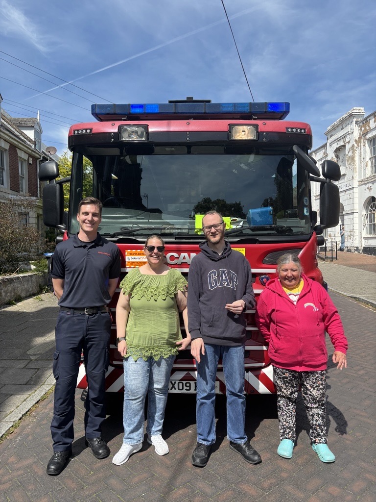 Fire Brigade from Ramsgate, standing in front of a fire engine with some of our members with a learning disability, as they came to chat about fire safety.