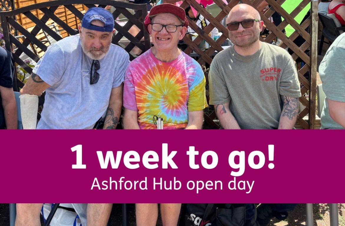 Three men sit together on a bench in the sunshine, smiling. They wear casual hats and sunglasses, and sit in front of a garden trellis. A purple banner over the photo reads: “1 week to go! Ashford Hub Open Day.”