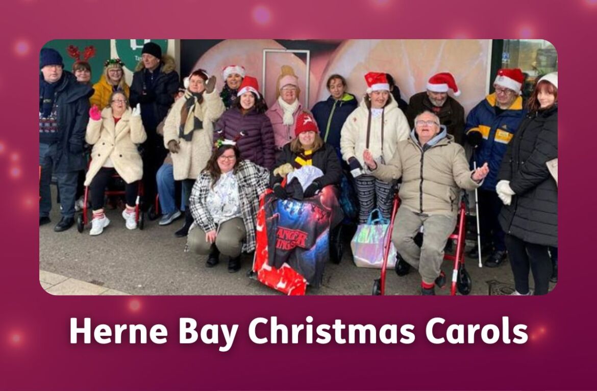 A group of members from East Kent Mencap’s Herne Bay hub stand together outdoors, many wearing festive Christmas hats and smiling.