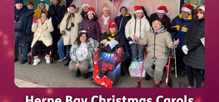 A group of members from East Kent Mencap’s Herne Bay hub stand together outdoors, many wearing festive Christmas hats and smiling.